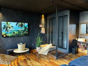 ein Wohnzimmer mit Stühlen und einem Fernseher an der Wand in der Unterkunft Casa Sabina Down Town Mexico City in Mexiko-Stadt