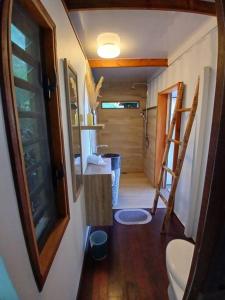 a small bathroom with a toilet in a tiny house at Fare Ohiti, face au spot de surf de Haapiti in Haapiti