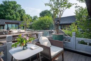 北京市にあるBeijing Le Zai Nan Luo Gu Xiang Wang Fu Jing Forbidden City Courtyard Hotel&Free laundry service&Free coffee &Paid Dumpling experience serviceの木のあるパティオ(テーブル、椅子付)
