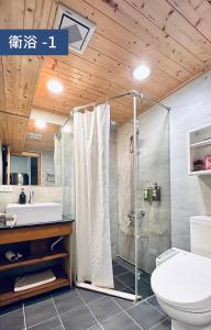 a bathroom with a shower with a toilet and a sink at 響水客棧 苗栗8-12人包棟 烤肉 特色老屋 in Gongguan