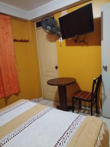una camera da letto con un letto e una TV a parete di Hostal paris a Nazca