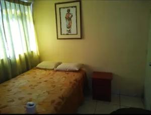 una camera da letto con un letto e un quadro sul muro di Hostal paris a Nazca