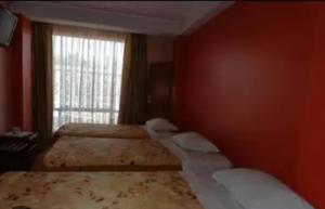 una camera da letto con due letti e una finestra di Hostal paris a Nazca