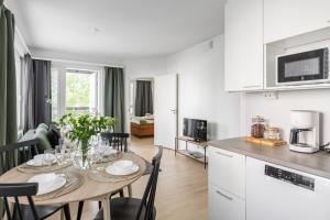 a kitchen and dining room with a table and chairs at Arctic Pine City Suite in Rovaniemi