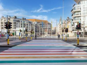 a street with a colorful striped sidewalk in a city at Ideal holiday home with garage in Blankenberge