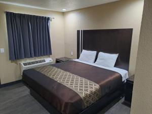 ein Schlafzimmer mit einem großen Bett in einem Hotelzimmer in der Unterkunft American Inn i10 Rialto and Colton in Rialto