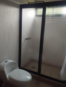 a white toilet in a bathroom with a window at Cabaña paraíso in Los Espinos