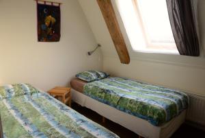 2 camas en una habitación pequeña con ventana en Appartementen verhuur De Trijehoek, en Stiens