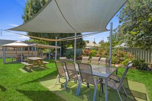 a table and chairs under an umbrella in a yard at Comfort Inn Benalla in Benalla