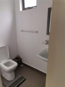 Un baño blanco con inodoro y lavabo. en Villa Allamanda, en Flic en Flac