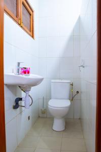 un baño con inodoro y lavabo en JRéside Appart Bleu 50m2 centre-ville, en Cotonou 19 fotos más