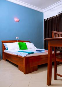 1 cama en una habitación con una pared azul en JRéside Appart Bleu 50m2 centre-ville, en Cotonou