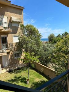 a view from the balcony of a house with a tree at Dimar3 Seaside Apartment in Paralia Dionysiou