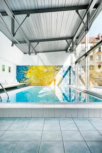 a swimming pool with a mural on the side of a building at Augarten Art Hotel in Graz
