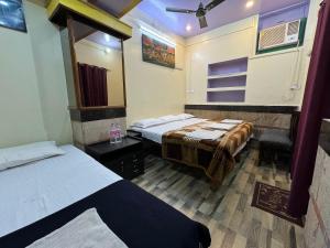 a room with two beds and a mirror at The Golden Lodge Varanasi in Varanasi