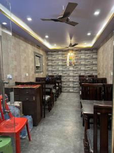 a restaurant with wooden tables and chairs and a ceiling at The Golden Lodge Varanasi in Varanasi