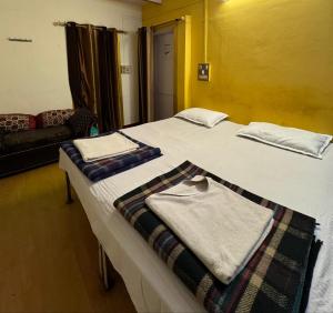 a hotel room with two beds with towels on them at The Golden Lodge Varanasi in Varanasi