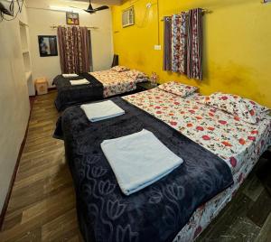 a room with two beds with towels on them at The Golden Lodge Varanasi in Varanasi