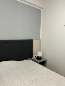 a bedroom with a white bed with a black headboard at Lazar ONE Aparment in Izola