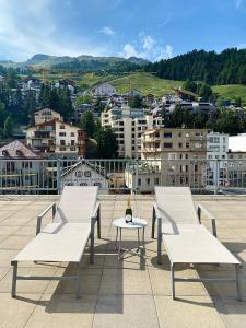 two white benches sitting on top of a roof at Crystal Hotel superior in St. Moritz