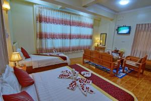 um quarto de hotel com duas camas e uma sala de estar em 79 Living Hotel em Mandalay