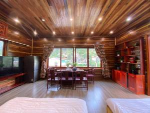 a dining room with a table and chairs and a tv at Lan Rừng Homestay in Lũng Niêo