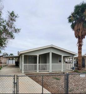 een huis met een veranda en een palmboom bij Cute and cozy river house! in Bullhead City