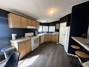 a large kitchen with wooden cabinets and white appliances at Cute and cozy river house! in Bullhead City