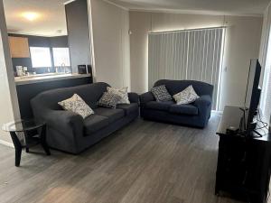 een woonkamer met 2 banken en een televisie bij Cute and cozy river house! in Bullhead City