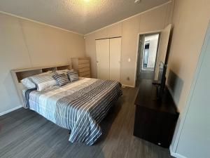 een slaapkamer met een bed met een gestreept dekbed bij Cute and cozy river house! in Bullhead City