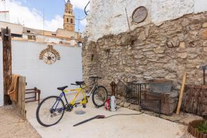 una bicicletta parcheggiata accanto a un muro con un edificio di Agroturismo "La Bardena Blanca II" ad Arguedas