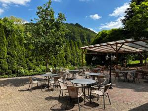 een groep tafels en stoelen met bomen op de achtergrond bij Hotel Thalfried in Ruhla