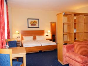 een hotelkamer met een bed en een boekenplank bij Hotel Thalfried in Ruhla