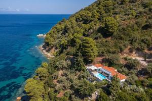 an aerial view of a house on a hill next to the ocean at Mourtia LA0414 in AthÃ©aton