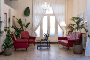a living room with red chairs and a table at Hotel Massimo in Marina di Cecina