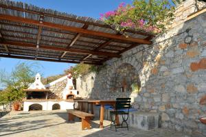 eine Terrasse mit einer hölzernen Pergola und einem Holztisch in der Unterkunft Hydra Erato in Hydra