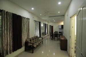 a living room with a couch and a dining room at Nest in Ernakulam