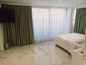 a hotel room with a bed and a marble floor at Ibiscus Hotel in Rhodes Town