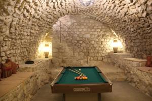 una mesa de billar en una habitación con una pared de piedra en Viladomatrural, en La Nou