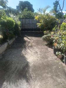 a backyard with a lot of plants and a fence at Maison 160M2 in Saint-Louis