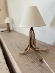 a wooden table with a lamp on top of it at Casa Au scheggiu de Sabetta in Calasetta
