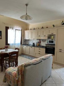 a kitchen with a couch and a table in it at Casa Au scheggiu de Sabetta in Calasetta
