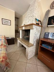 a living room with a stone fireplace in a room at Casa Au scheggiu de Sabetta in Calasetta +28 photos