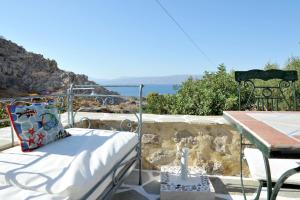 a bed on a balcony with a table and a table at Hydra Erato in Hydra