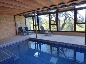 a house with a swimming pool with chairs and windows at Viladomatrural in La Nou