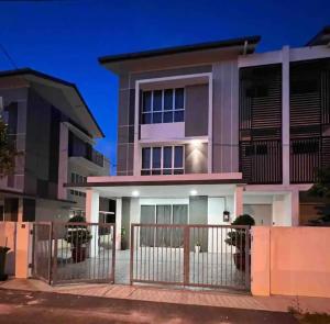 ein Haus mit einem Zaun davor in der Unterkunft Kuala Selangor Moonlight Sweet Home Semi-D 20Pax in Kuala Selangor