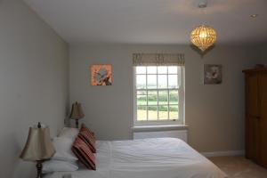 a bedroom with a bed and a window at Beautiful farm house with dedicated sitting and media room for guest's use in Charwelton