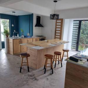 a kitchen with a island with bar stools in it at Maison familiale in Curepipe +26 photos