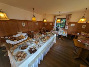 a long table with food on it in a room at Hotel Eden Guesthouse in Marlengo