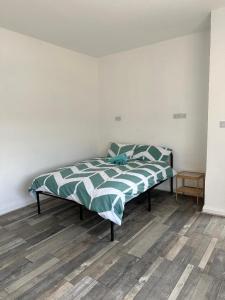 Cama en habitación blanca con suelo de madera en Shakespeare House 6 bedroom 10 beds stay up to 14 people, en Derby 2 fotos más